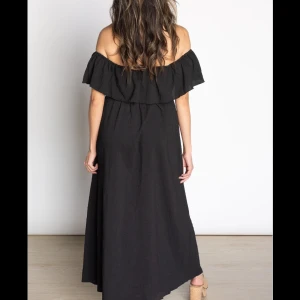 Svart offshoulder klänning - Säljer en elegant svart offshoulder klänning med volangdetaljer. Perfekt för sommarens fester eller en kväll ute. Klänningen är lång och har en lös passform som ger en bekväm och stilren look.