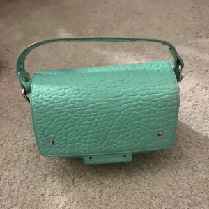 Grön väska  - Säljer denna mintgröna/turkosa väska från núnoo. Den är lite smutsig på både insidan och utsidan som syns på bilderna.💕Den är 18cm*8cm*11cm.💕Originalpris 2000kr.🩷