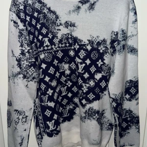 Mönstrad tröja från Louis Vuitton - Säljer en tvär fett tröja från Louis Vuitton med ett unikt mönster i blått och vitt. Tröjan har långa ärmar och är perfekt för att sticka ut i mängden. Den är både stilren och bekväm, perfekt för både vardag och fest!