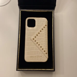 ”BEATSTUDS CREAM CROCO” skal från Ideal of sweden💕 - Hej!💕 Säljer detta trendiga ”Ideal of sweden” skal. Ett skinn skal med en smidig ficka för till exempel kort.  Helt oanvänt. Köptes för bara två veckor sedan. Skalet är till en iPhone 11 PRO.  Hör av er för flera bilder om de önskas eller frågor!💕 