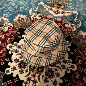 Burberry bucket hat  - Hej, vill sälja min oanvända burberry bucket hat. Den är reversibel, alltså kan den vändas in och ut om man föredrar svart.