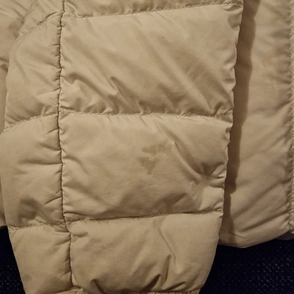 Säljer en superlätt och varm beige dunjacka från Parajumpers. Jackan har en dragkedja framtill och en mysig huva för extra skydd mot kylan. Perfekt för ungdom. Den är i storlek Y/L och i bra skick. Finns dock en synlig fläck.. Jackor.