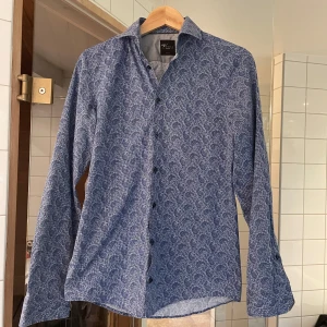 Blå mönstrad skjorta från Venti - Säljer en snygg blå skjorta från Venti med paisley mönster. Skjortan sitter slimfit 