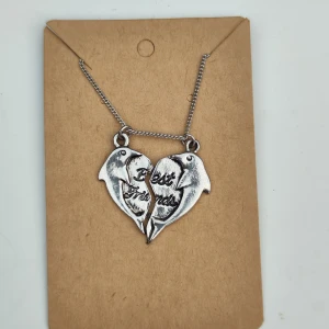 Silverfärgat Best Friends-halsband - Säljer ett superfint silverfärgat halsband med två delfiner som bildar ett hjärta. Texten 'Best Friends' är ingraverad i mitten. Perfekt present till din bästa vän! 🐬💖
