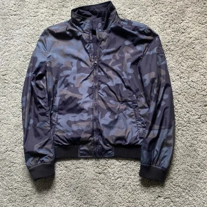 Woolrich jacka/S - Säljer nu min stilrena Woolrich, mkt bra skick, inget slitage, säljer den enbart pga storleken inte passar mig.  Man kan vända jackan och antingen ha den svarta sidan eller cammo-sidan utåt. Se bilder. Fickor finns på båda hållen! Frakt sker spårbart