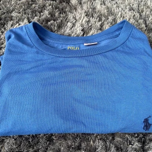 Blå långärmad tröja från Polo Ralph Lauren - Säljer en snygg blå långärmad tröja från Polo Ralph Lauren. Perfekt för både vardag och lite finare tillfällen. Tröjan är i bomull och har en klassisk passform. Den är i bra skick och redo för en ny ägare! Storlek 170 XL passar S/M