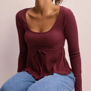 Cute hem tie top  - Vinröd topp från Nelly i storlek S. Använd en gång annars nyskick. Säljer då den va för kort för mig🫶🏼