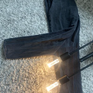 Svarta jeans i regular fit - Säljer ett par svarta jeans i regular fit. De är i storlek 31/32 och har en klassisk design med knapp och dragkedja framtill. Perfekta för både vardag och fest!