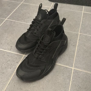 Svarta sneakers från Nike - Säljer ett par svarta Nike Air Huarache  i nyskick, använda en gång.  Perfekta för både vardag och träning. Skorna är bekväma och ger bra stöd. Storlek 38