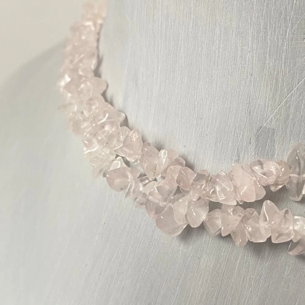 Säljer en superfin choker med små rosa stenar. Den har en naturlig och bohemisk stil som passar perfekt till både vardag och fest. Stenarna är oregelbundna och ger ett unikt utseende. Låset är i metall och håller halsbandet säkert på plats. Perfekt för att ge din outfit en extra touch av elegans!. Accessoarer.