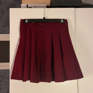 Röd kjol - Kjolen är luftig och väldigt utvidgad och passar perfekt på sommaren eller till ett bar höga skor på vintern. 