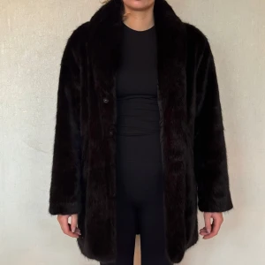 Svart pälsjacka - Längre modell från bubbleroom Storlek M - 38/40 Personen på bilden är 170 cm 