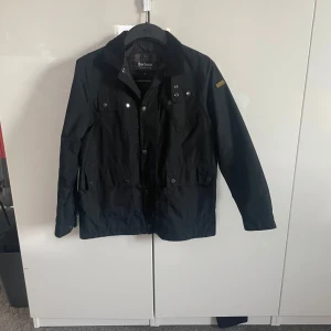 Barbour field jacket - En Barbour field jacket i barn storlek xl, är i fint skit men dragkedjan är sönder men de finns knappar som funkar exakt lika bra