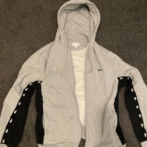 Lacoste kofta grå och svart - En Lacoste kofta i färgen grå och svart. Storlek L. Pris kan diskuteras:).