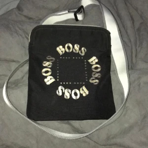 Hugo Boss väska svart vit guld. Sällsynt!! - Säljer min Hugo Boss väska som är väldigt svår att få tag på. Den är fri från defekter samt tobaksvaror. Varende detalj sitter som den ska. Pris kan diskuteras vid seriöst köp!! Södertälje 📍📍