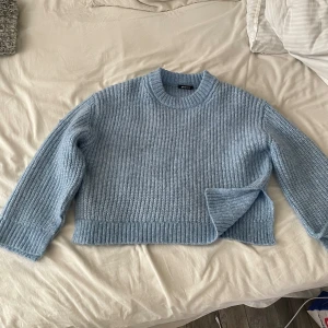 Ljusblå stickad tröja - Säljer en supermysig ljusblå stickad tröja. Den har en normal passform med långa ärmar och en rund halsringning. Perfekt för kyliga dagar när du vill vara både varm och stilren. Passar till både jeans och kjol!