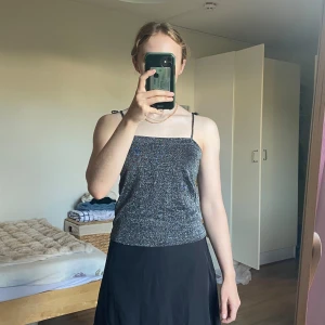 Glittrigt linne / festtopp - Ett glittrigt linne perfekt till fest! Storlek 40 står det, men jag brukar oftast bära S eller M och har lite mindre byst. Axelbanden är längre, men jag har knytit ihop dem i rosetter som går att ta ut (bandet är ej avklippt). Fint skick!