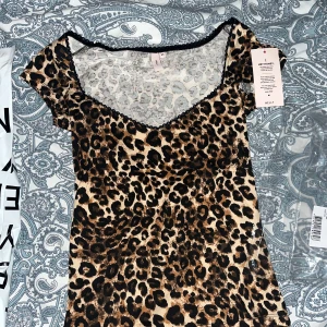 Leopardmönstrad topp från Nelly - Säljer den virala och supersnygga leopardmönstrade toppen från Nelly. Den har korta ärmar och en snygg v-ringning med svart spetskant. Perfekt för fest eller skola. Köpte för 2 dagar sedan men den va för stor så säljer den direkt. Prislappen sitter kvar och förpackning finns. Nypris 250 för jag köpte de nya som precis kom ut då från att dem var slut i hela Sverige! 🐆✨ Skriv för fler bilder💕