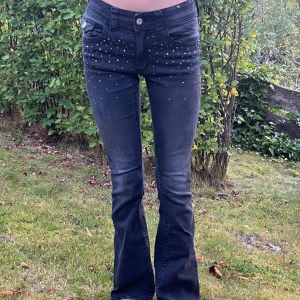 Svarta bootcut  - Svarta bootcut jeans med paljetter, fin passform i använt skick.  Strl 158-164