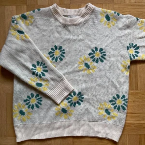 Vit stickad tröja med blommönster från Saltlimit - Vit stickad tröja från Saltlimit med blommönster i grönt och gult! 