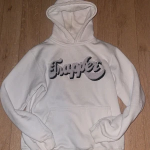 MadeByTrapper hoodie - Vit hoodie från MadeByTrapper som jag köpte sommarn 2023, den är i storlek Medium men är liten i storleken så skulle säga Small! Nypris låg på 800kr men säljer för 300kr då den har tecken av användning!