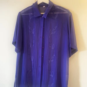 blus - Jättefin vintage blus i klar blå färg med fina detaljer. Är i superbra skick och sparsamt använd.