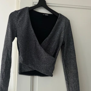 Glittrig topp - En glittrig långärmad crop top 