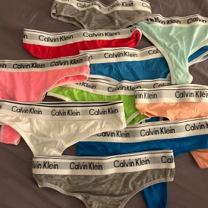 Calvin Klein trosor flerpack - Oanvända Calvin Klein stringtrosor, dem är oäkta men ser väldigt autentiska ut. Står att dem är i storlek M-L men det är dem verkligen inte, väldigt små i storleken och är som en XS-S i storlek. Väldigt fina färger. 10 st. Köparen står för frakt!
