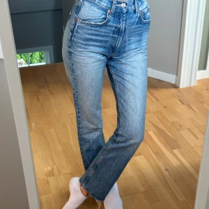 Blå jeans med hög midja - Säljer ett par snygga blå jeans med hög midja. De har en klassisk straight fit och är perfekta för både vardag och fest. Jeansen har en dragkedja och knappar framtill samt fickor både fram och bak. flared modell