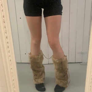 Benvärmare äkta päls - Benvärmare äkta päls med band där bak till där man kan spänna in eller ut efter behov. Fint skick