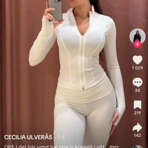 Gina trico sett  -  Tunn jacka med dragkedja fram. Jackan är beige och har figurnära passform. Den har hög krage, ribbad kvalitet och tumhål. Kommer även med byxorna byxorna är s och tröjan är M eftersom den är midre i storleken prislapp finns kvar på tröjan 