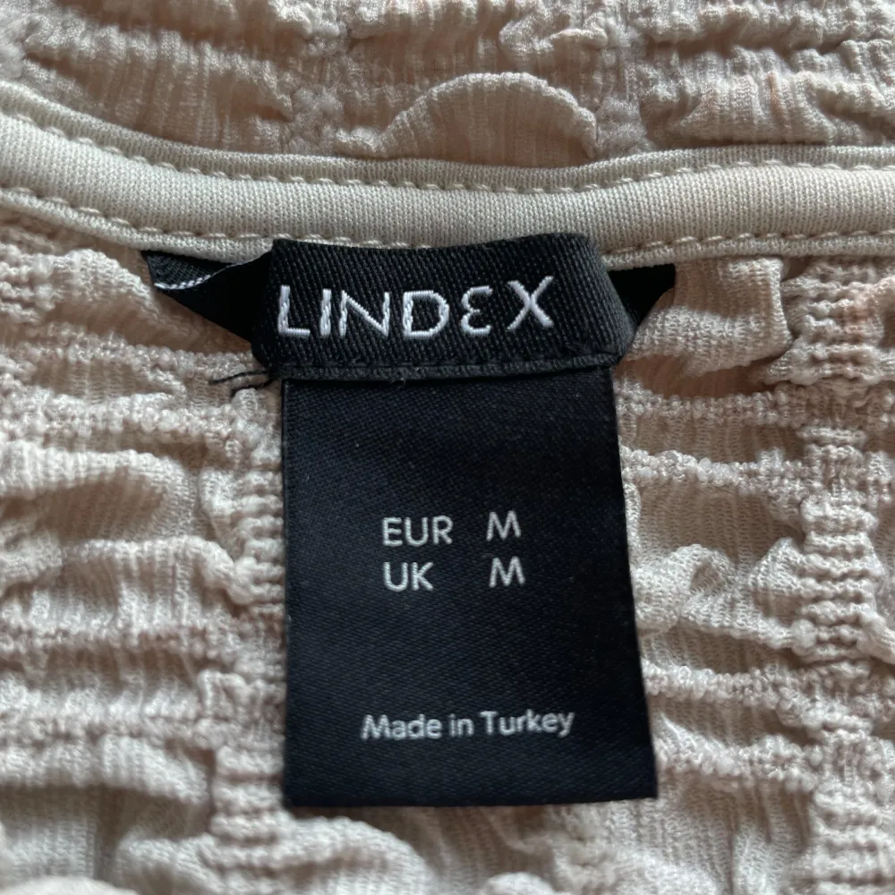 Beige t-shirt med ett fint rutigt mönster, från Lindex, storlek M. T-shirts.