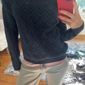 Svart stickad tröja - Säljer en snygg marinblå stickad tröja med ett fint hålmönster. Tröjan är långärmad och perfekt för höst och vinter. Den är både stilren och bekväm, perfekt för att hålla sig varm och trendig.