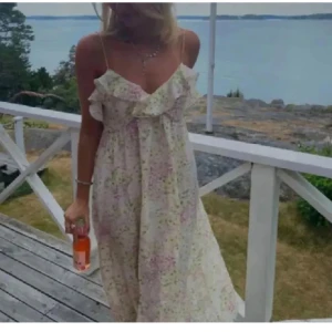 Blommig sommarklänning med volangdetaljer - Söt blommig klänning med tunna axelband och volangdetaljer vid bysten. Perfekt för varma sommardagar med sitt luftiga och lätta material. Mycket bra skick