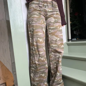 Camouflage cargopants - Snygga camouflage cargopants med låg midja och raka ben. Byxorna har flera fickor och en klassisk militärinspirerad look. Perfekta för en avslappnad stil.