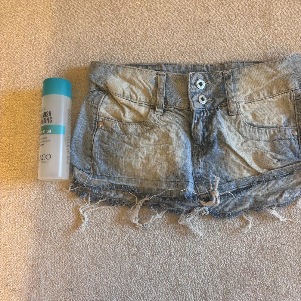 Säljer en cool jeanskjol från Bershka i ljusblå denim. Kjolen har en kort längd med slitna kanter och två knappar framtill. Perfekt för en avslappnad stil. Även lågmidjad. Säljer pågrund av flytt och för mycket kläder☺️☺️ lite skrynklig då jag inte har strukit den. Hameet.