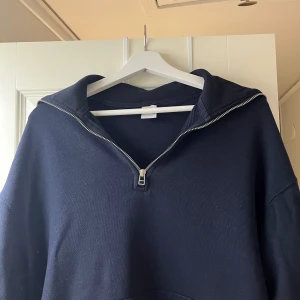 Zara zip-up - Säljer en stilren mörkblå tröja från Zara med dragkedja vid halsen. Perfekt för en avslappnad look. Tröjan har långa ärmar och en bekväm passform.