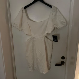 Vit studentklänning från Parallel Lines - Säljer en elegant vit klänning från Parallel Lines. Klänningen har en offshoulder-design med korta ärmar och en figurnära passform. Perfekt för sommarens alla tillfällen. 💫 