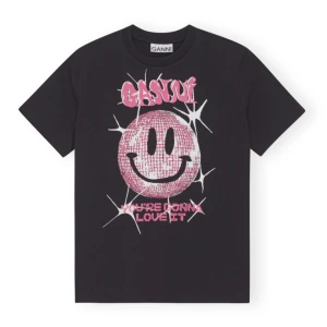 Svart t-shirt med smiley från Ganni - Säljer denna jättefina Ganni T-shirt med en rosa smiley på. Den är i väldigt bra skick. 