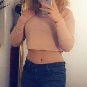 Ljusrosa croppad långärmad topp - Säljer en croppad långärmad topp. Perfekt för en stilren och avslappnad look. Passar bra till jeans eller kjol. Hör av dig vid intresse!