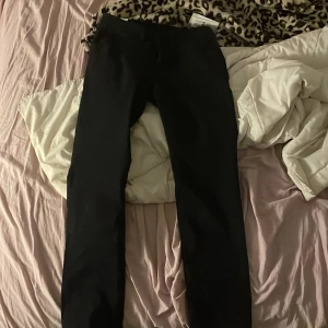 Svarta byxor - Snygga svarta byxor med en clean och enkel design. Perfekta för en stilren look. De har en rak passform och är tillverkade i ett mjukt material för extra komfort. I storlek w30 L32