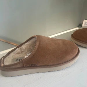 Bruna tofflor från UGG -  Nya bruna tofflor från UGG. Använda 1-2 gånger kort. Riktigt bra skick. Skriv om ni har frågor eller prisförslag. Storlek 41. Original pris 1500kr