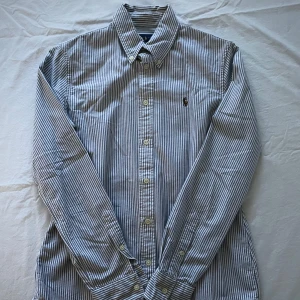 Ralph Lauren Skjorta - Ralph Lauren Skjorta | Skick: 9/10 (sparsamt använd) | Färg: Randig vit/ljusgrå | Nypris: 1995kr | Mitt pris: 449kr | Tveka inte på att ställa frågor i dm!💯