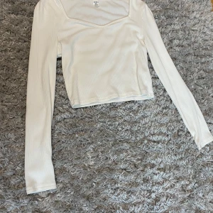 Vit ribbad topp från Shein - Säljer en stilren vit ribbad topp från Shein. Toppen har en v-ringad design och långa ärmar, perfekt för en trendig look. Passar bra till både jeans och kjol. Perfekt för dig som vill ha en enkel men snygg outfit.Pris kan alltid diskuteras🥰