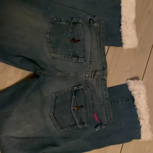 Lågmidjade jeans - Y2k jeans jag köpte second hand men va lite korta för mig så sydde en fluffig kant längst ner på benen, Skiiitt snygga🥰🥰