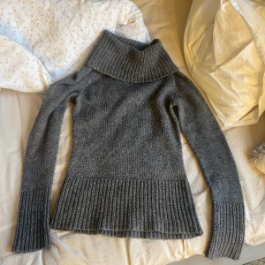 Grå stickad polotröja - Säljer en mysig grå stickad tröja från Lindex. Är helt ny då jag fick den i julklapp förra året.