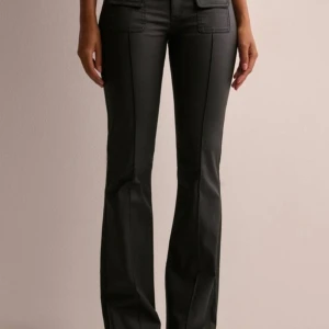 Svarta skinnbyxor med bootcut - Snygga svarta lågmidjade skinnbyxor med bootcut-stil. Aldrig använda, prislapp finns fortfarande kvar. 