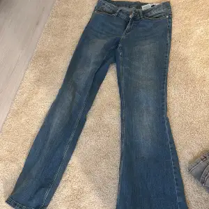 Säljer ett par klassiska blå jeans i bra skick. De har en straight passform och är perfekta för vardagsbruk. Jeansen har en knapp och dragkedja framtill samt fickor både fram och bak. Perfekta för höst och vår!