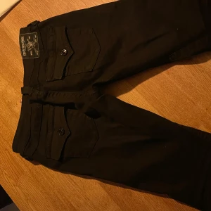 True religion Joey Low Rise Flare byxor - Snygga svarta Joey Low Rise Flare byxor , helt nya använt 1 gång men säljer då dom inte passar mig så bra i benen, storlek 27. Nypris 1299, kvitto kan skickas ifall nån vill. Ge gärna förslag och frågor :) vill sälja så snabbt som möjligt 