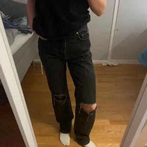 Svarta jeans från Gina Tricot - Säljer ett par svarta jeans från Gina Tricot i storlek 32. De är högmidjade och har en loose fit med slitna detaljer på knäna. Säljer pga att de är stora💞